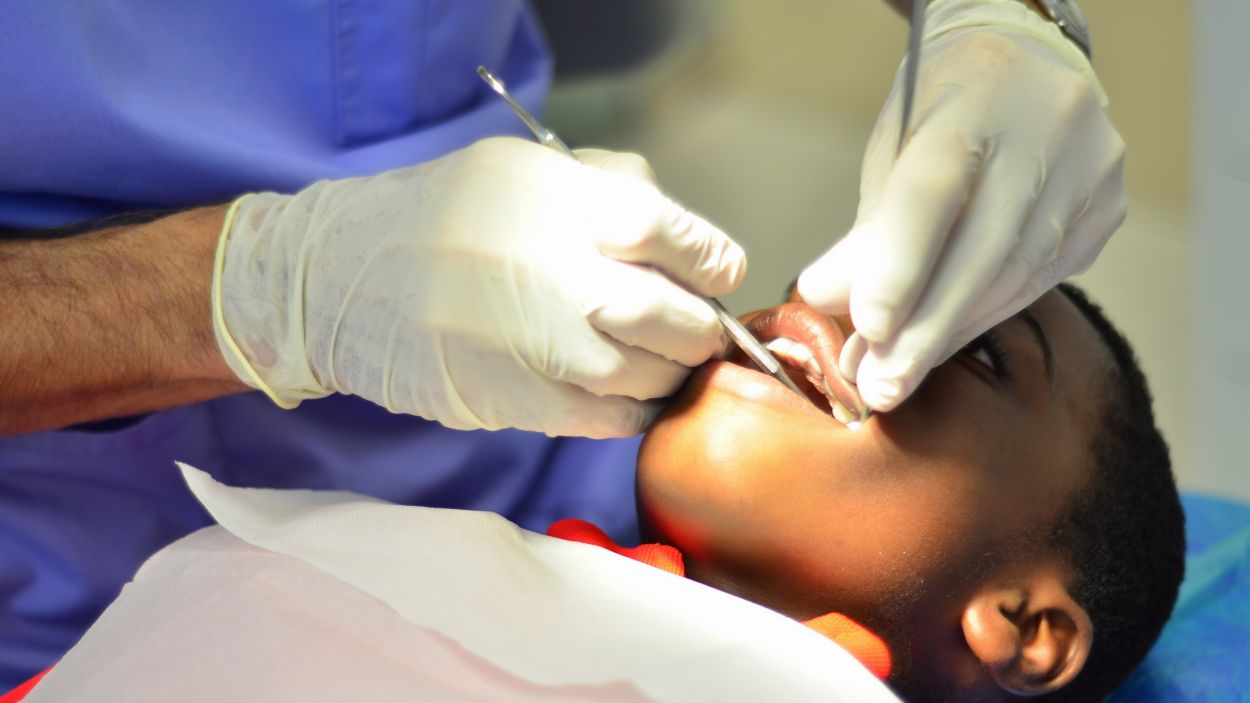Un dentista fent una revisió bucal a un infant / Foto: Fundació 