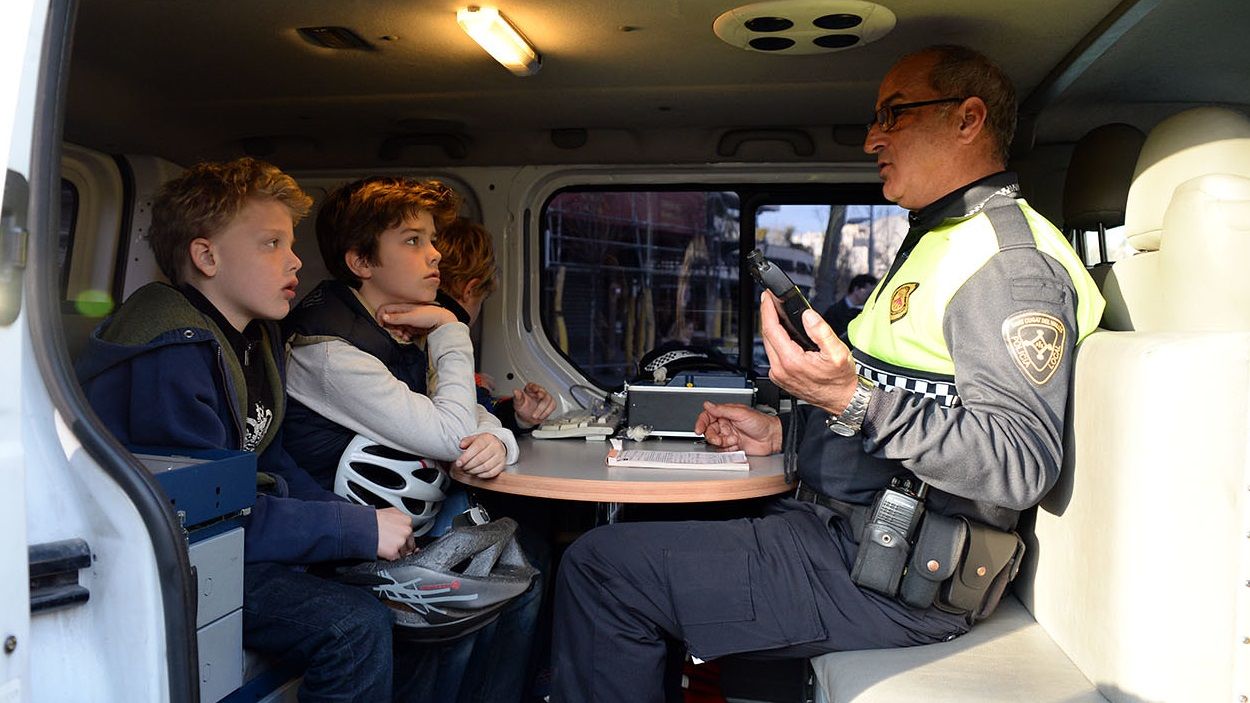 Un agent de la Policia Local parlant amb uns nens / Foto: Cugat Mèdia