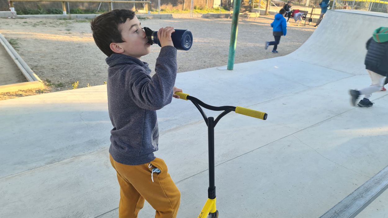 Un nen beu aigua mentre fa esport en un parc / Foto: Cugat Mèdia