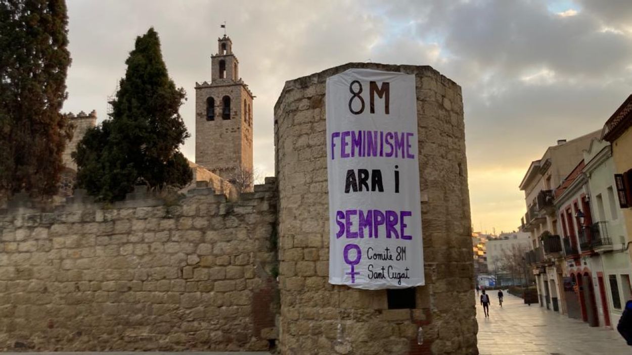 Un cartell del 8M penjat a la muralla del Monestir / Foto: Comit 8M