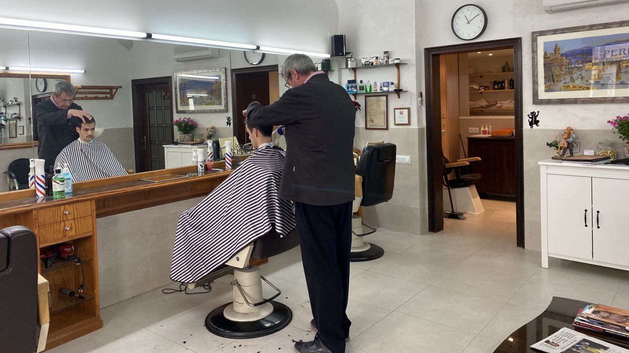 El propietari Joan Llongueras tallant el cabell a un client