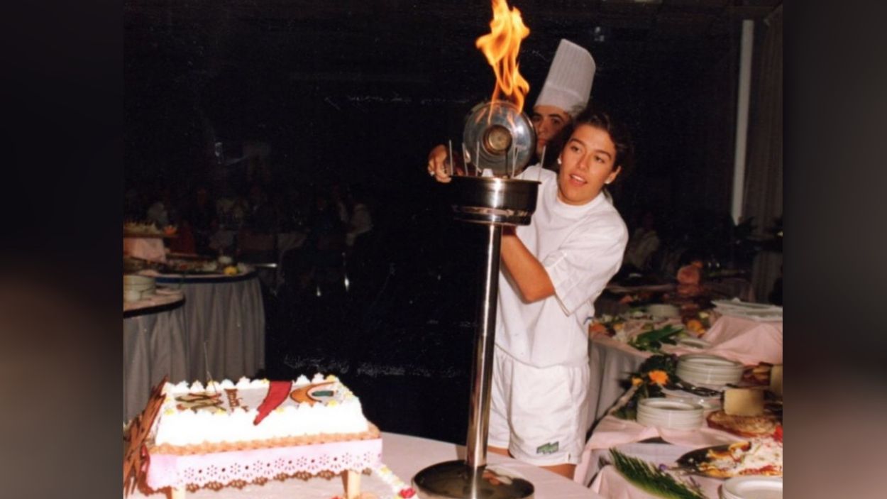 Una atleta santcugatenca encén les espelmes d'un pastís amb la torxa olímpica / Foto: Canals Galeria d'Art