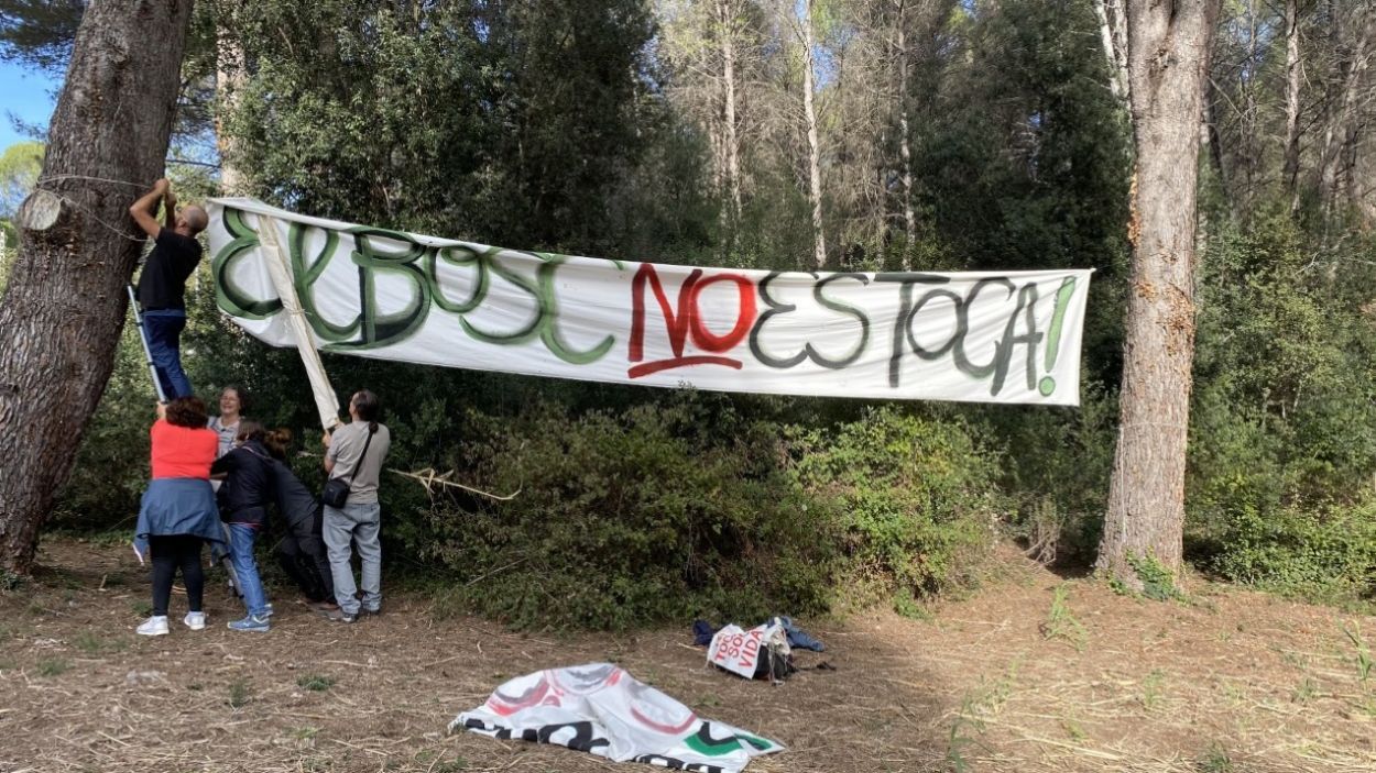 Els membres de SOS Bosc de Volpelleres, penjant un dels cartells