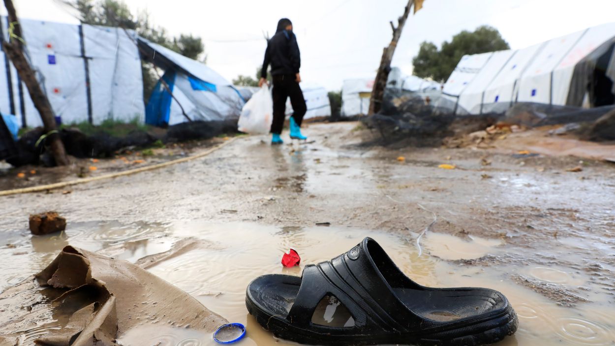 Un refugiat camina durant la pluja en un campament improvisat als afores del camp de Moria, a Lesbos, el 29 de novembre del 2018 / Foto: ACN - Oxfam - Giorgos Moutafis