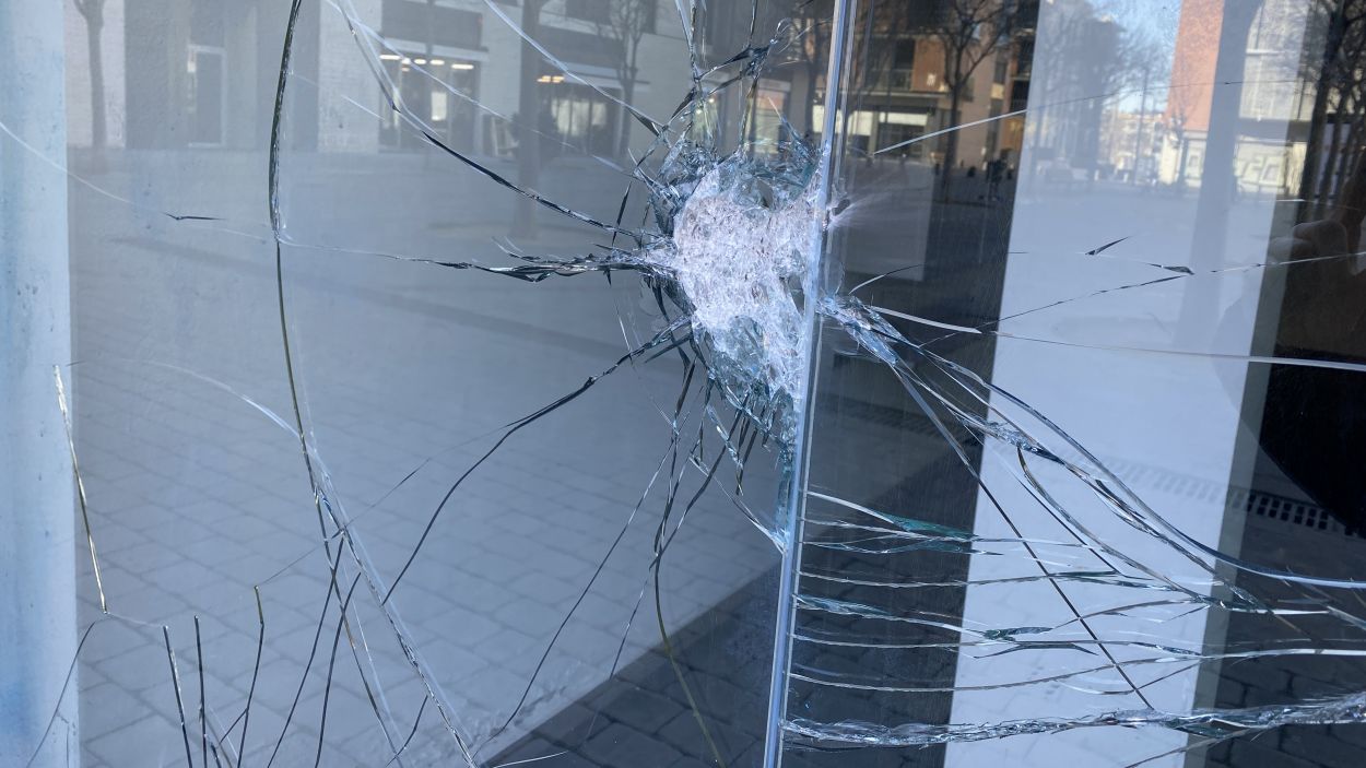 El vidre trencat de l'entrada de l'immoble de la plaça dels Rabassaires