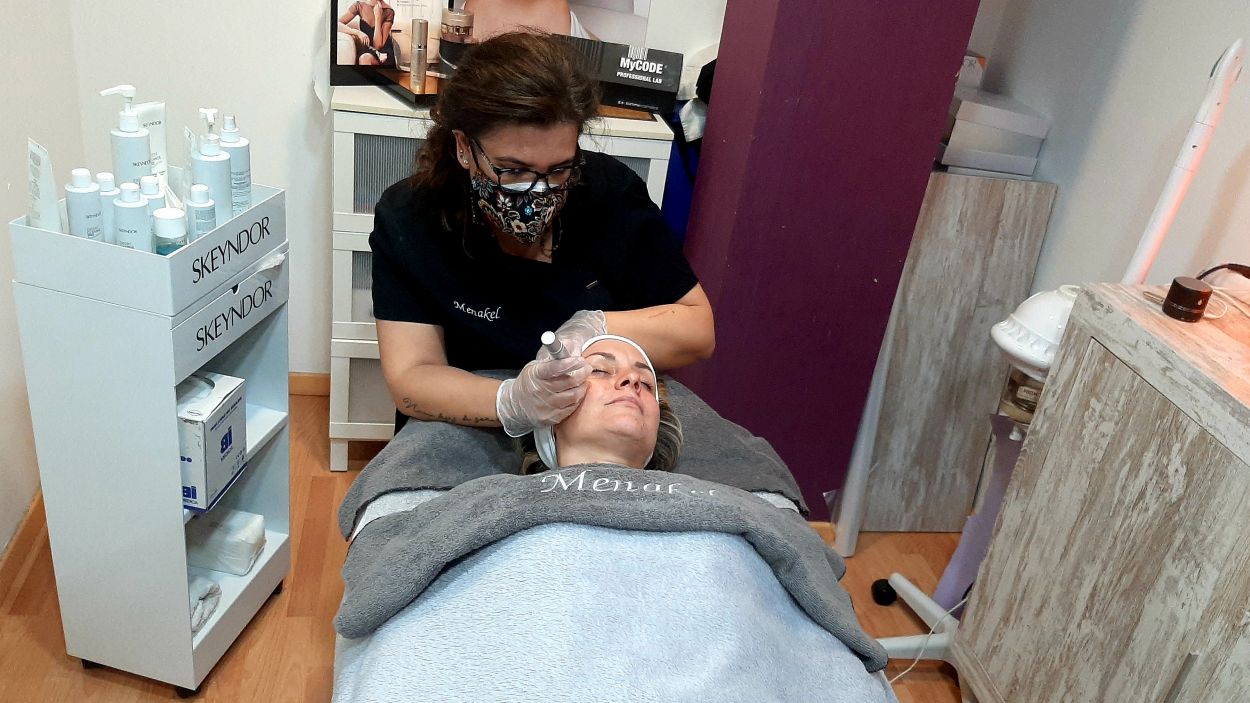 Sánchez aplica un tractament facial a una clienta/Foto:Cugat Mèdia