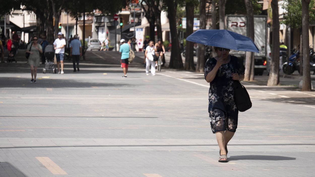 Una dona protegint-se del sol amb un paraigua a la rambla del Celler / Foto: Llus Llebot (Cugat Mdia)