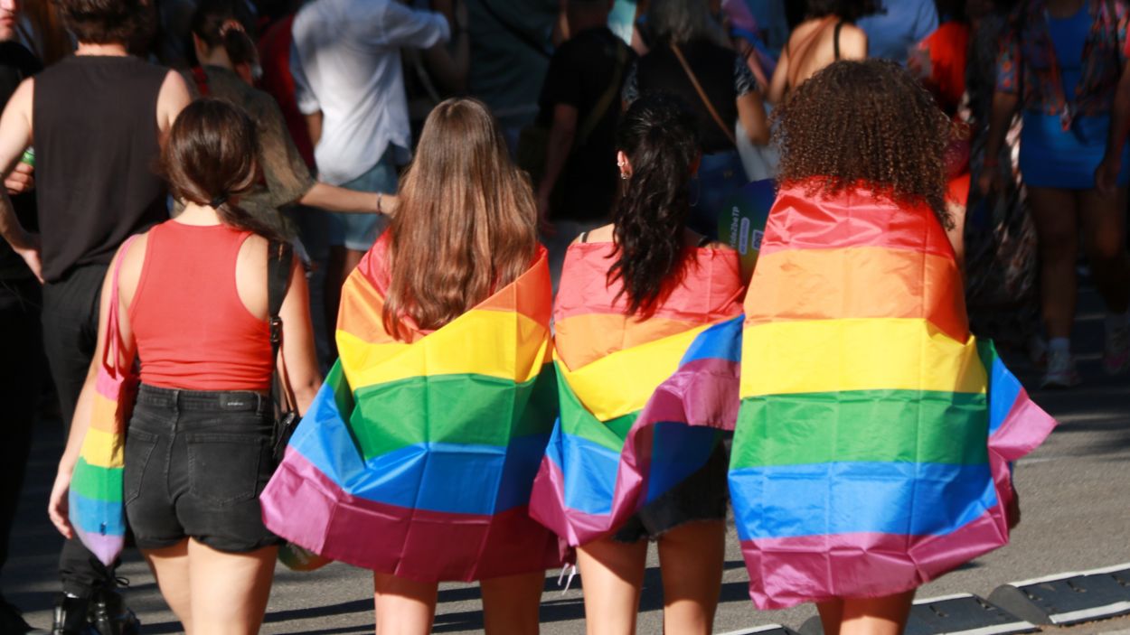 Quatre noies d'esquena amb la bandera LGTBI durant la rua del Pride de Barcelona / Foto: Natlia Segura (ACN)