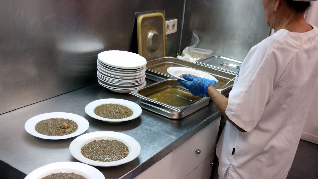 Una treballadora omplint els plats de llenties per a la gent gran d'un centre de dia / Foto: ACN (Pol Sol)