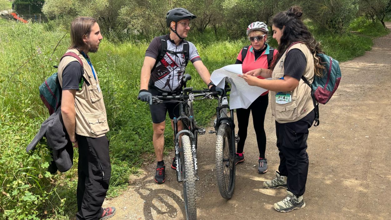 Una de les dues parelles d'informadors del Parc Natural de Collserola explicant a dos ciclistes per on poden circular per tenir cura de l'espai Una de les dues parelles d'informadors del Parc Natural de Collserola explicant a dos ciclistes per on poden circular per tenir cura de l'espai