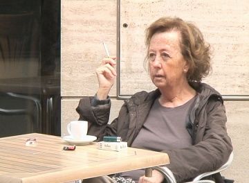Una dona fumant a una terrassa