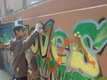 Un nen pintant un altre mur del Casal
