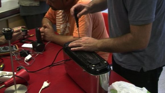Un usuari del taller arreglant un electrodomèstic